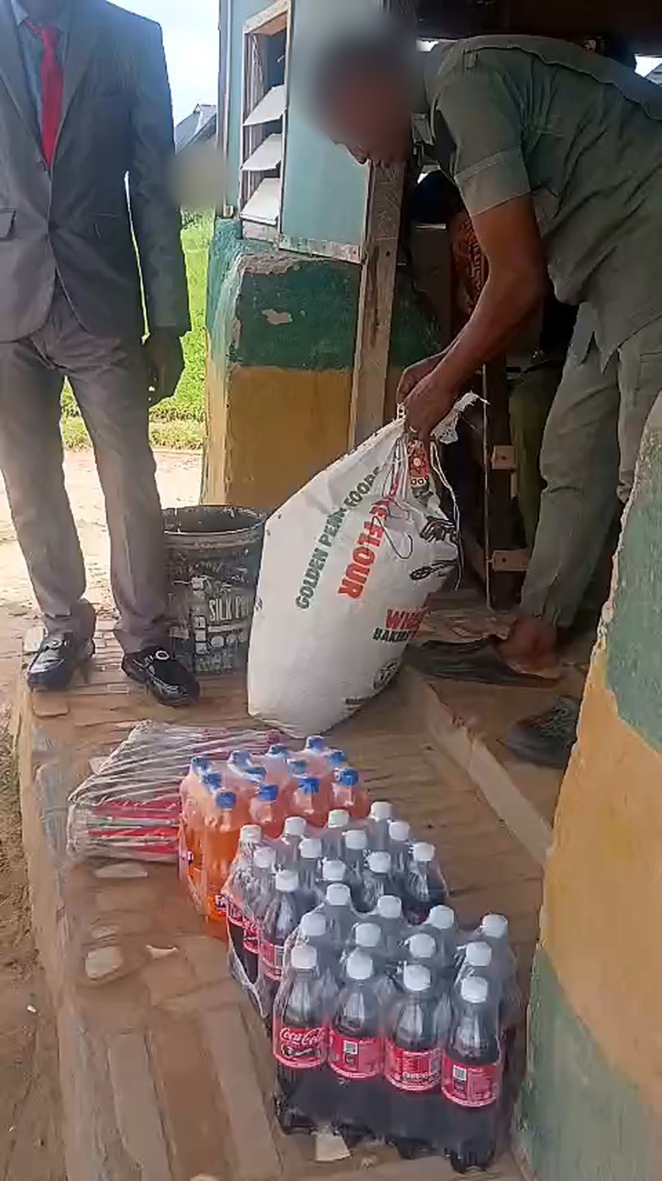 A custodial officer receiving bags of rice and drinks